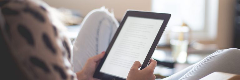 Woman Sitting on Chair Using Black Ipad
