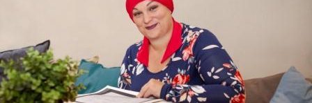 Genealogist Natalie Pithers at a table with books